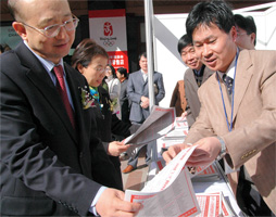 中國質量檢驗協(xié)會工作人員在咨詢活動現(xiàn)場向支樹平副局長詳細介紹《消費知識·名優(yōu)企業(yè)宣傳手冊》。